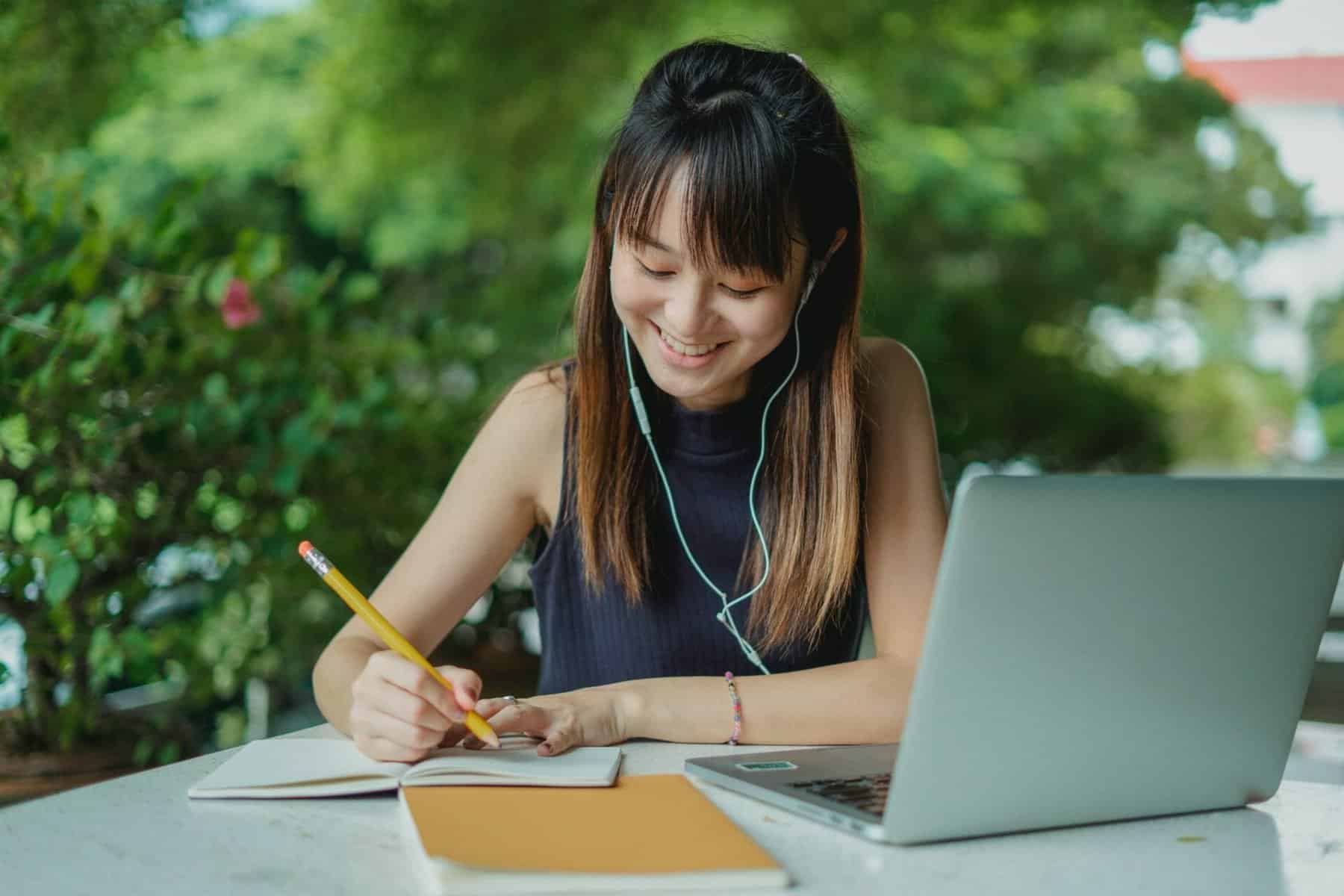 Student studying on laptop and notebook