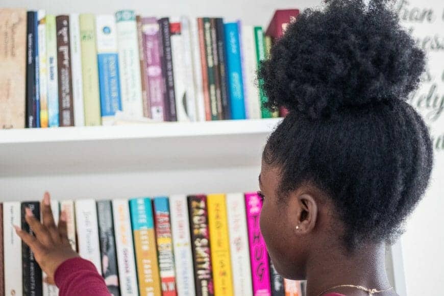 Black person looking at book shelf